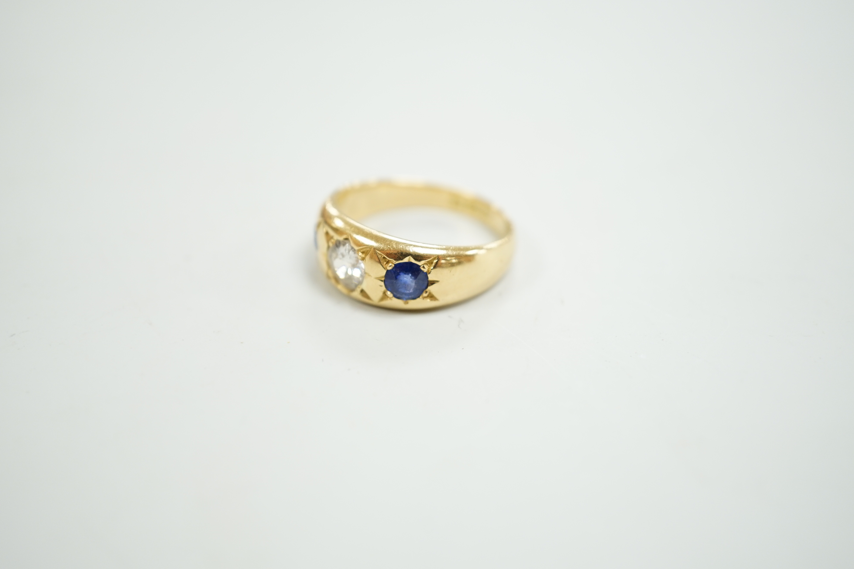 An early 20th century 18ct gold and gypsy set single stone diamond and two stone sapphire set ring, size O, gross weight 6.4 grams.
